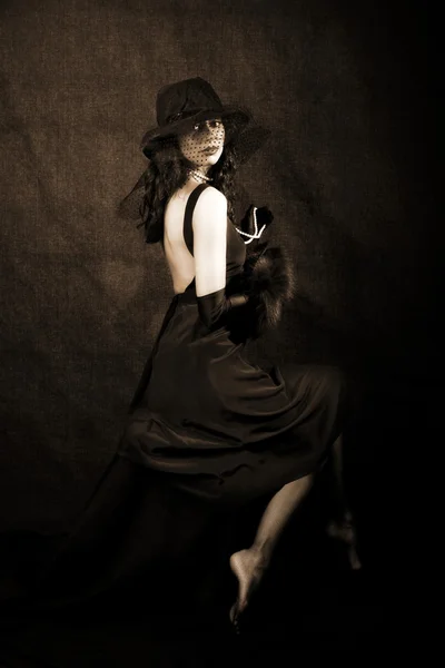 Девушка в шляпе на черном фоне — стоковое фото