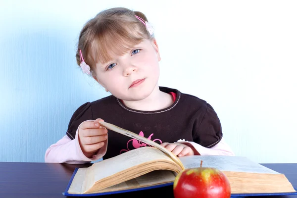 Mädchen mit Apfel und Büchern — Stockfoto