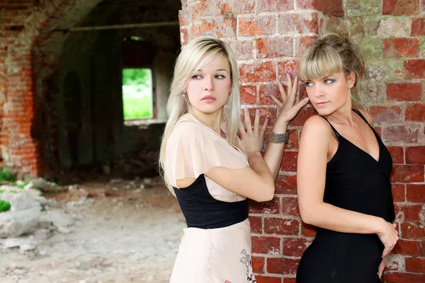 Two girls at old brick wall — Stock Photo, Image