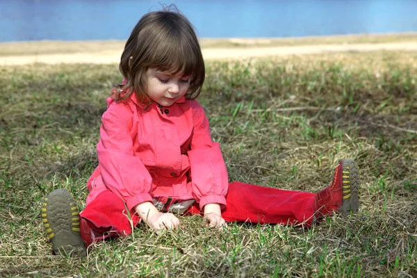 Meisje in gras buiten spelen — Stockfoto