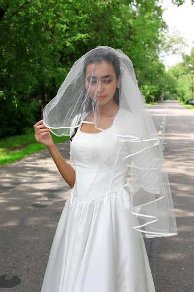 Mariée en robe blanche sur la route à l'extérieur — Photo