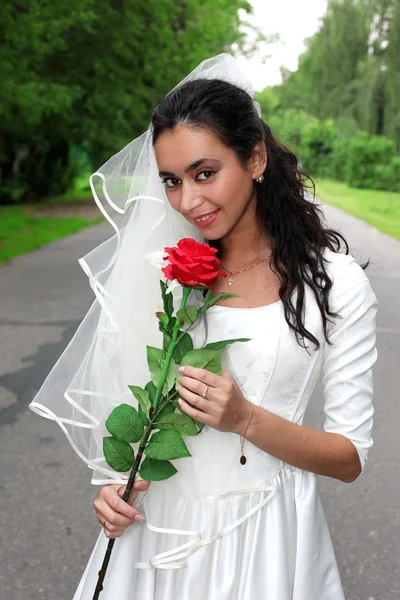 Novia en vestido blanco con flor roja — Foto de Stock