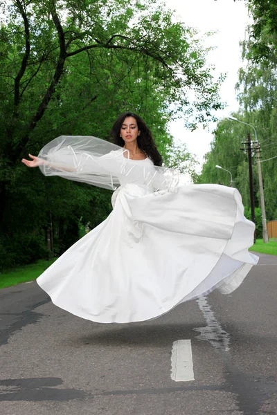 Vliegende bruid in witte jurk — Stockfoto