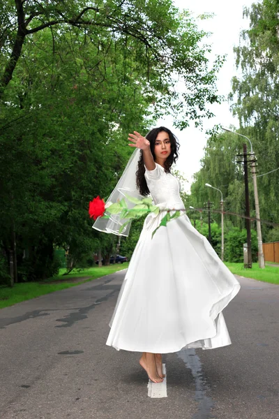 Bruid met rode vliegende bloem op weg — Stockfoto
