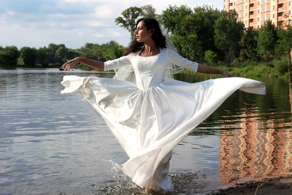 Bride with flying dress at pond — Stock Photo, Image