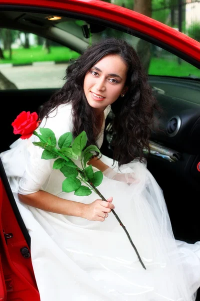 Brud med blomma, sitta på bilen — Stockfoto