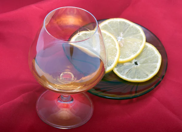 Cognac on a red fabric. — Stock Photo, Image