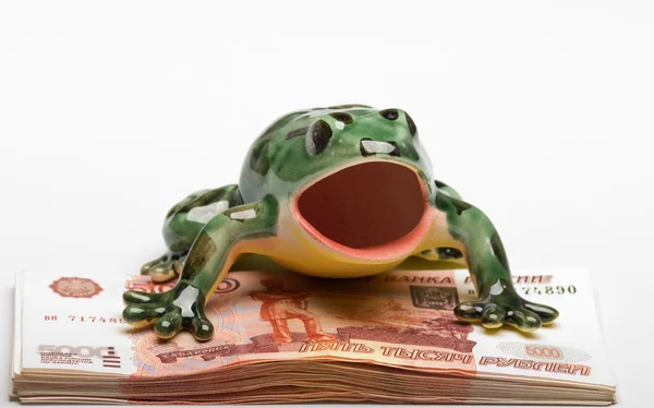 Керамічна жаба на купі п'ятитисячного — стокове фото