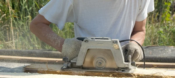 stock image The man with a circular saw