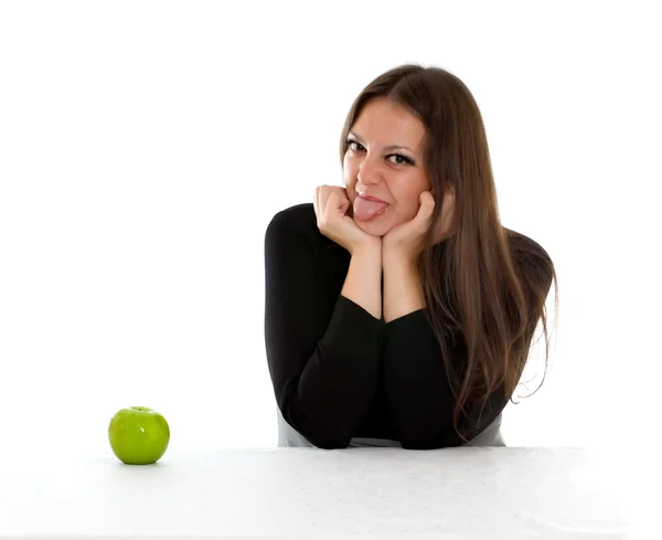 Mädchen mit grünem Apfel zeigt Zunge — Stockfoto