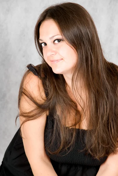 Lächelnde junge Frau mit langen braunen Haaren — Stockfoto