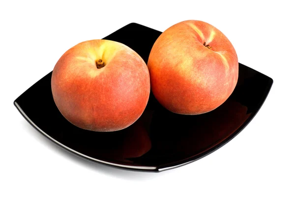 Red peaches on black dish — Stock Photo, Image