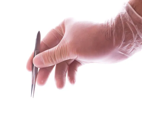 Рука в резиновой перчатке с пинцетом — стоковое фото