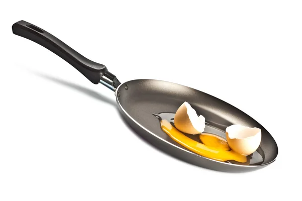 Сырое яйцо и скорлупа на черной сковороде — стоковое фото