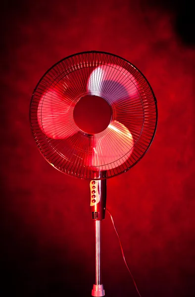 Офісний вентилятор на темно-червоному тлі — стокове фото