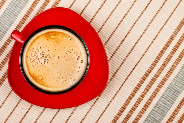 Red coffee cup on tablecloth — Stock Photo, Image
