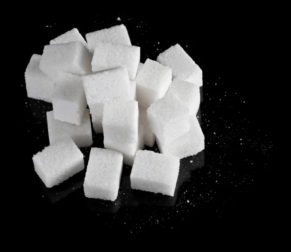 Pieces of sugar on black — Stock Photo, Image