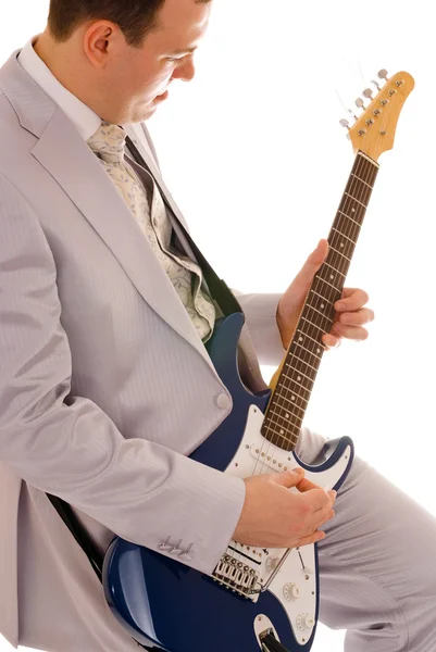 Человек в белом костюме играет на гитаре — стоковое фото