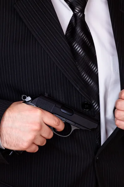 Man drawing his gun from jacket pocket — Stock Photo, Image