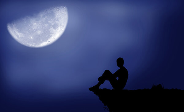Black silhouette of a boy which sits under the moon