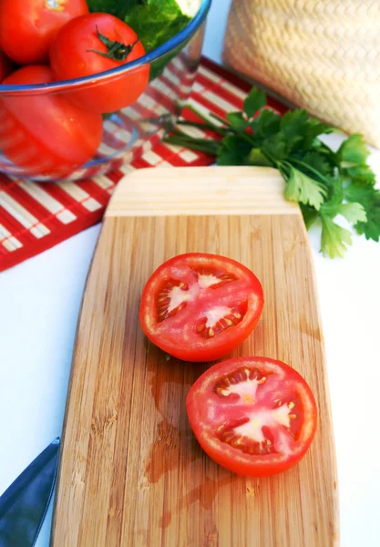 Tomates maduros en rodajas sobre una tabla de madera — Foto de Stock