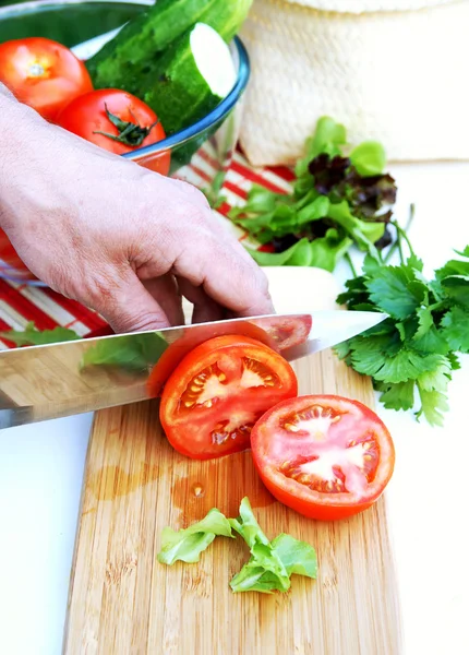 Man cuts ripe tomatoes for summer vegeta — Stock Photo, Image