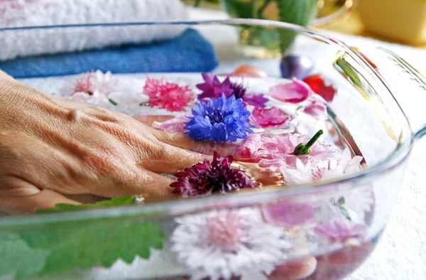 Женщина пожилая рука лежит в стеклянной раковине — стоковое фото