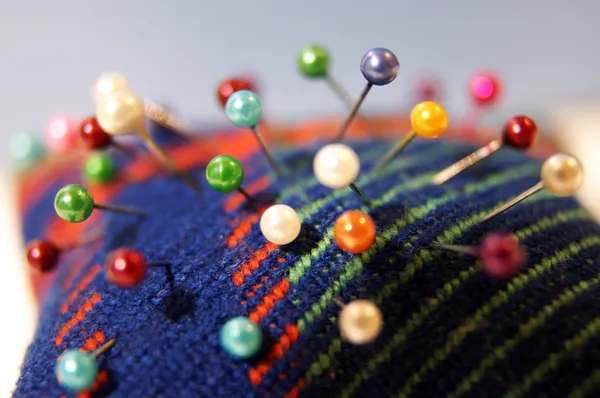 Cama de agulha colorida com alfinetes Fotografias De Stock Royalty-Free