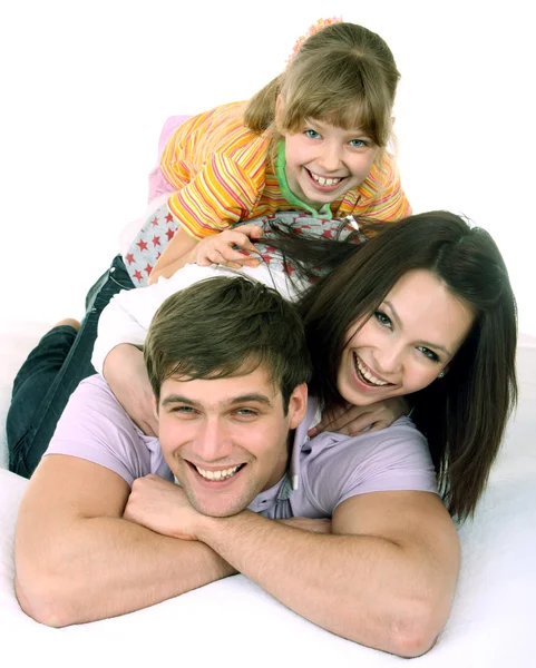 Gelukkige familie op witte bed. — Stockfoto