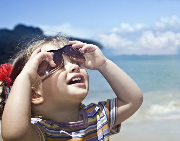 Girl in sunglasses at sea coast.
