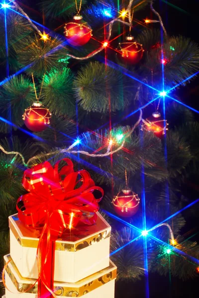 Christmas tree with flash and gift box. — Stock Photo, Image