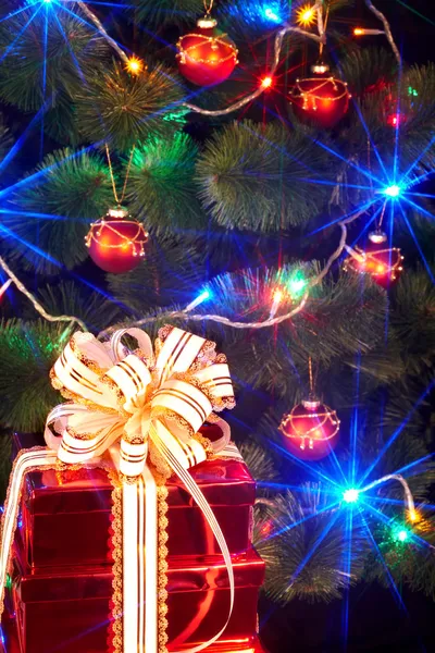 Christmas tree with flash and gift box. — Stock Photo, Image