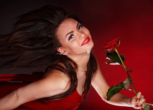 Dívka s červeným květem růže běží. — Stock fotografie