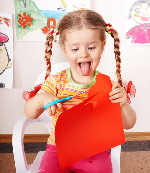 Kind met scharen snijdt papier — Stockfoto