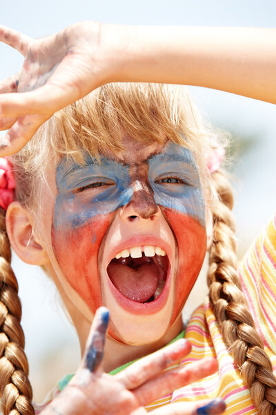 Child with paint on face and hand.