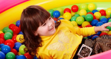 Girl with ball in play room. clipart