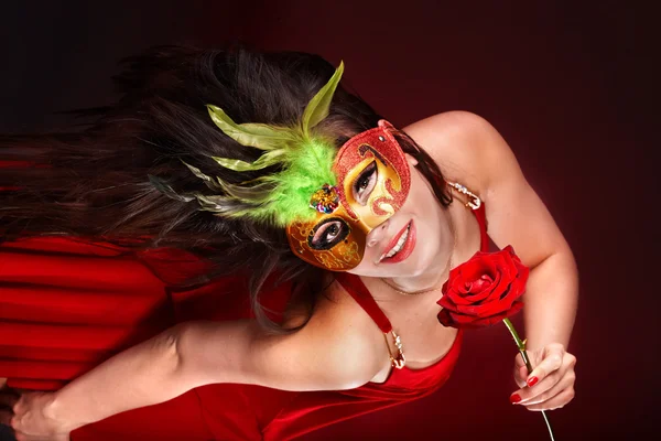 Dívka s rudou růži a maska. — Stock fotografie