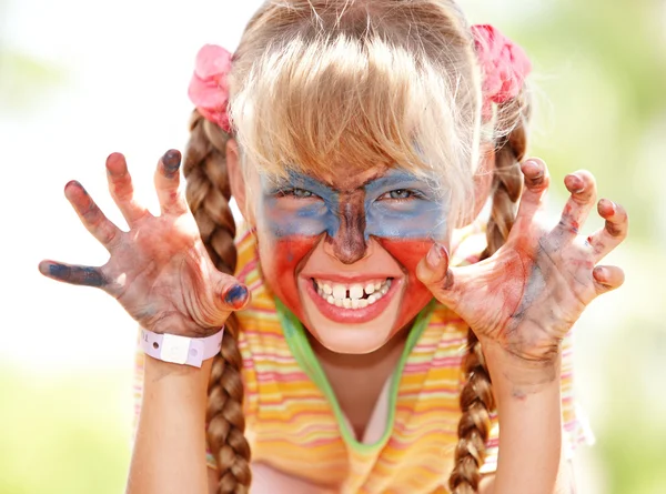 Kind meisje met verf op gezicht. — Stockfoto