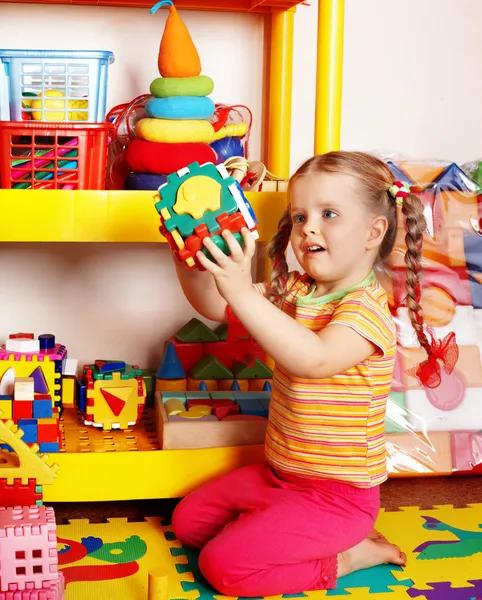 Criança com quebra-cabeça e bloco na sala de jogos — Fotografia de Stock