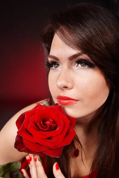 Flicka med ros på röd bakgrund. — Stockfoto