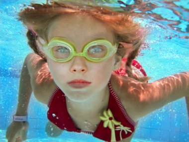 Child girl swim underwater in pool. clipart