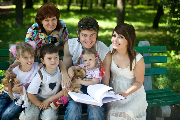 Счастливая семья в книгах для чтения на свежем воздухе — стоковое фото