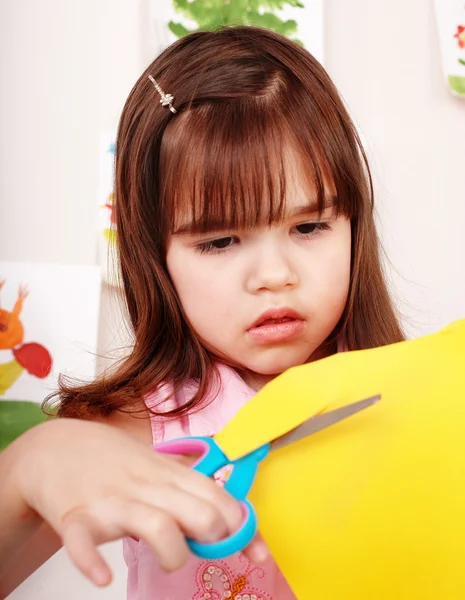 Child with scissors cut paper — Stock Photo, Image