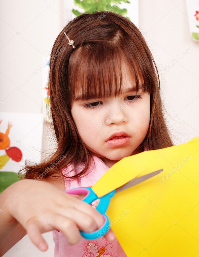 Child with scissors cut paper