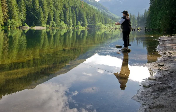 Mujer pesca con mosca en un lago — Foto de Stock