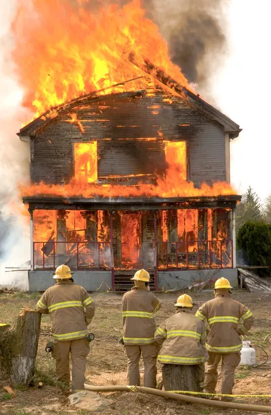 Brandmän på ett brinnande hus — Stockfoto