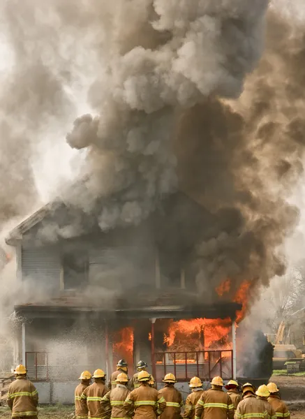 Πυροσβέστες σε ένα φλεγόμενο σπίτι Royalty Free Εικόνες Αρχείου