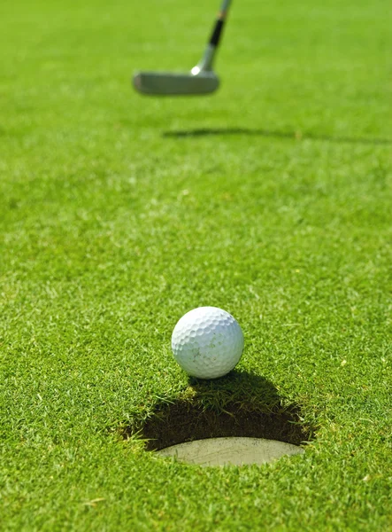 Golfball rollt auf Loch zu — Stockfoto