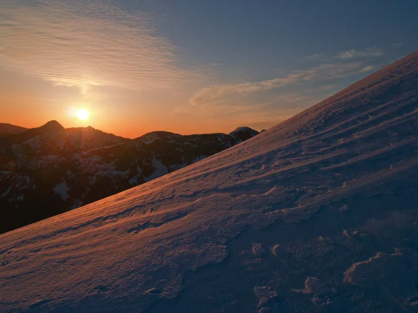 Sonnenuntergang auf einem schneebedeckten Bergrücken — Stockfoto