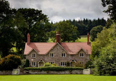 Pair of cottages surrounded by meadows clipart